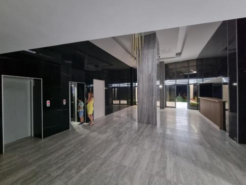 two people standing in a large building with a lobby at Denis apartament 2 camere in Olimp