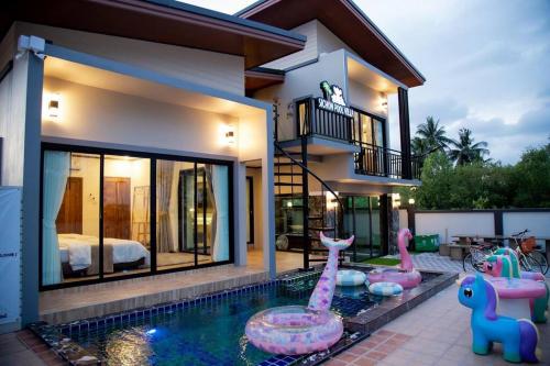 une maison avec une piscine en face d'une maison dans l'établissement สิชลพูลวิลล่า -Sichon Pool Villa, 
