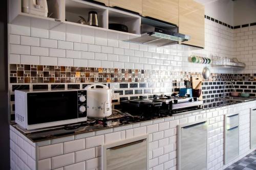 a kitchen with white tiled walls and a counter top at สิชลพูลวิลล่า -Sichon Pool Villa 