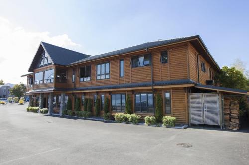 a large wooden house with a lot of windows at Lakefront Lodge Taupo in Taupo