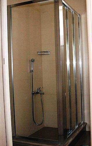 una doccia con una porta in vetro in un bagno di Naiades Villas a Karistos