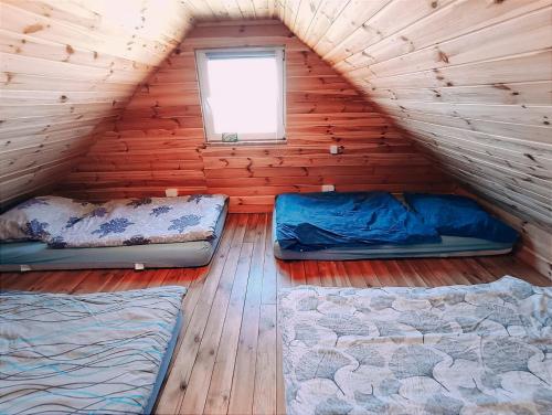 drie bedden in een houten kamer met een raam bij nr.2 - W POLU DOBREJ ENERGII 
