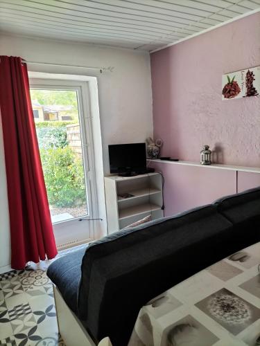 a living room with a bed and a window at Le clos des cigales jasmins in Le Thoronet