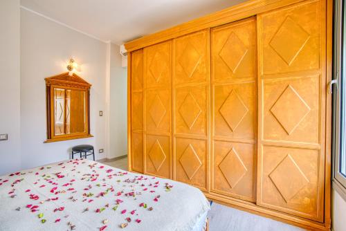 a bedroom with a large wooden headboard and a bed at The Suites near AUC by Elegant Hospitality in Cairo