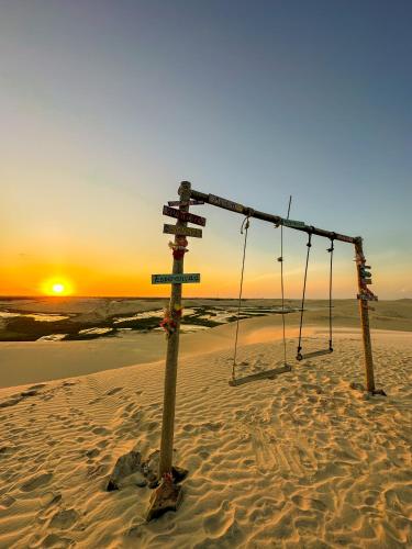 an empty swing on the beach at sunset at Hotel Vento Brasil in Paracuru