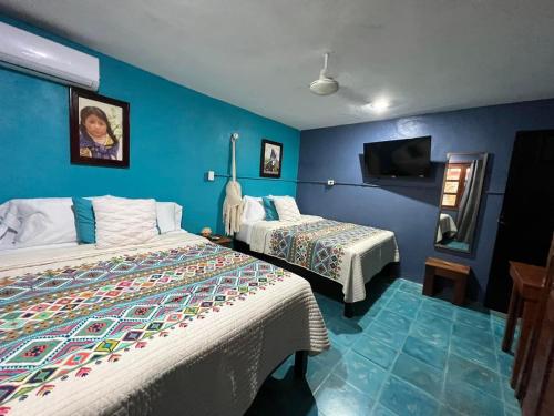 Cette chambre comprend 2 lits et une télévision. dans l'établissement The Mermaid and The Pearl Boutique B&B, à Isla Mujeres