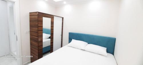 um quarto com uma cama branca e um espelho em Çeşme holiday homes em Cesme