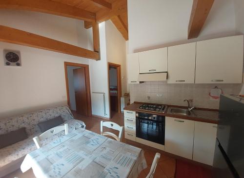 a kitchen with white cabinets and a table with chairs at Appartamenti Enrica in Moneglia