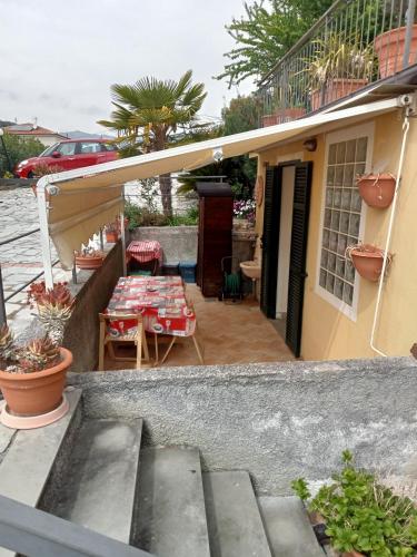 a patio with a table and a table at Nina House in Imperia