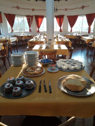 a table with plates of food on it in a restaurant at Castelar - Hotel & Apart in Huerta Grande