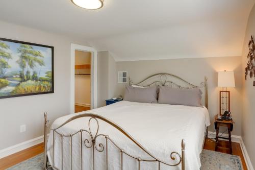 a bedroom with a white bed and a painting on the wall at Chic Home with Deck, Walk to Lake Erie! 