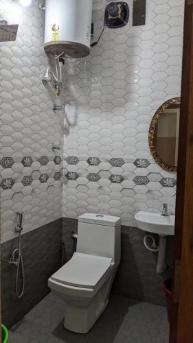 a bathroom with a toilet and a sink at Rainbow Comforts in Chikmagalūr