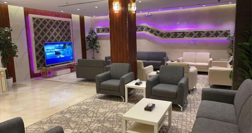 a lobby with couches and a tv in a room at فندق العزم in Hafr Al Baten