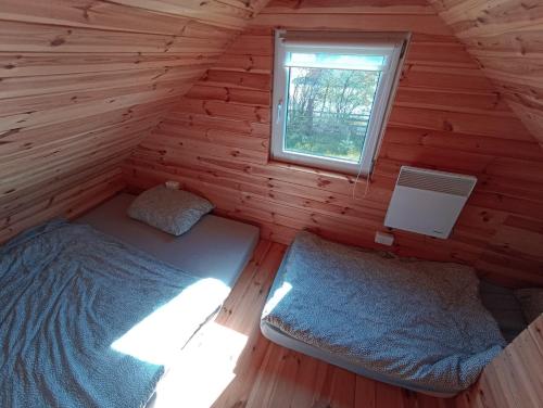 two beds in a log cabin with a window at Nr3 - W POLU DOBREJ ENERGII 