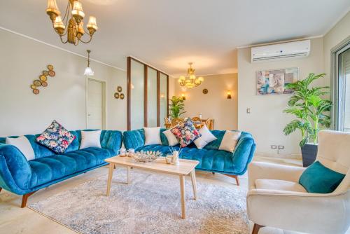 a living room with blue couches and a table at The Suites near AUC by Elegant Hospitality in Cairo