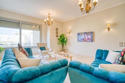 a living room with blue couches and a table at The Suites near AUC by Elegant Hospitality in Cairo