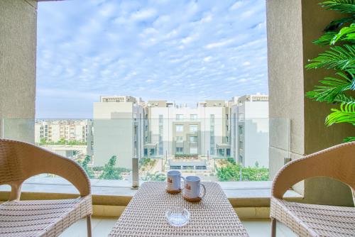 a table with two mugs on it in front of a window at The Suites near AUC by Elegant Hospitality in Cairo
