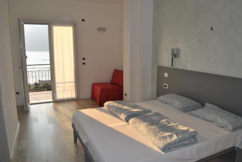 una camera con letto e sedia rossa di Hotel Casa Gagliardi a Brenzone sul Garda
