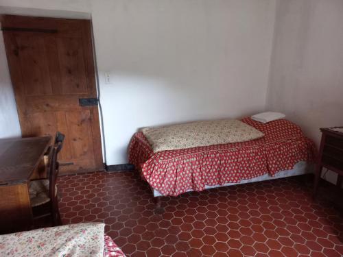 1 Schlafzimmer mit 2 Betten und einer Holztür in der Unterkunft Chambre dans maison de caractère in La Bastide