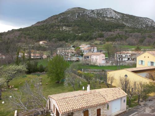 ein kleines Dorf mit einem Berg im Hintergrund in der Unterkunft Chambre dans maison de caractère in La Bastide