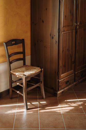 a wooden chair sitting next to a cabinet at Villa Nottola in Montepulciano