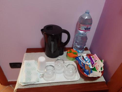 una mesa con tetera y una botella de agua en Piccola Perla Guest House, en Valmontone