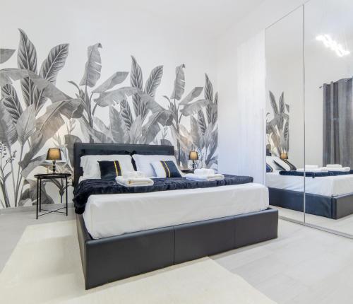 een slaapkamer met 2 bedden en een muurschildering van planten bij Tropical - Boutique Apartment in Gallipoli