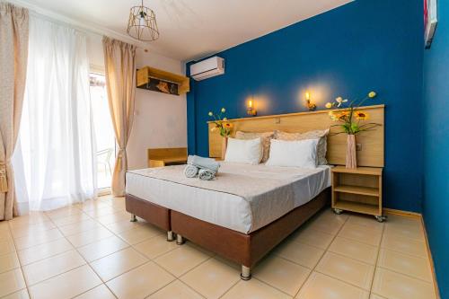 - une chambre dotée d'un lit avec un mur bleu dans l'établissement Aegean Blue Studios, à Neos Marmaras