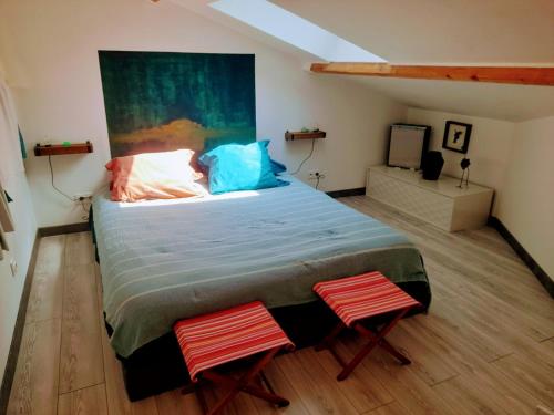 een slaapkamer met een groot bed en 2 stoelen bij l atelier d alex in La Baule