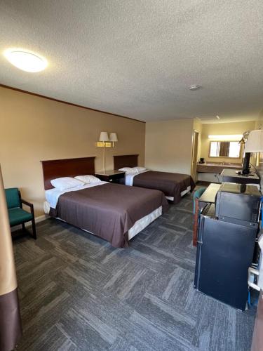 a hotel room with two beds and a desk at Green Valley Motel Winston Salem in Winston-Salem