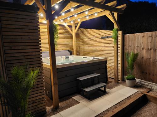 a bath tub in a backyard with a pergola at XxHot TubxX 4Bed semi, sleeps 8, 2 bathrooms in Blackpool