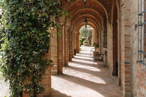 an alleyway with an archway with an ivy covered building at Villa Nottola in Montepulciano