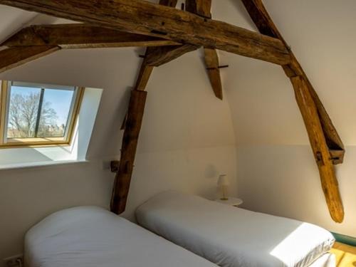 a room with two white beds and a window at Maison du Moulin in Donzy