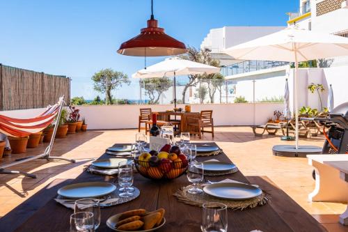 a wooden table with a bowl of fruit on a patio at Stunning terrace with ocean view in Albufeira
