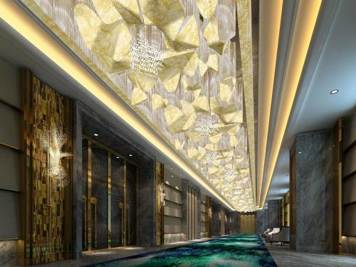 a lobby of a hotel with a large stone wall at Wanda Vista Nanning in Nanning