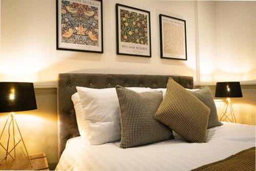 um quarto com uma cama com almofadas e 2 candeeiros em Stylish Apartment close to Beach & Town Centre em Prestatyn