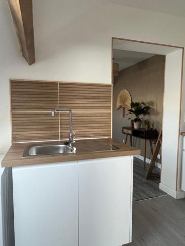 a kitchen with white cabinets and a sink at l'Ambre de Calais - Elégance et plénitude in Calais