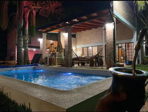 una piscina frente a una casa por la noche en Rincón del Potro en Paso de la Patria
