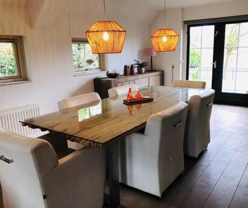 una sala da pranzo con tavolo e sedie in legno di Vakantiehuis Villa 56 a Heel