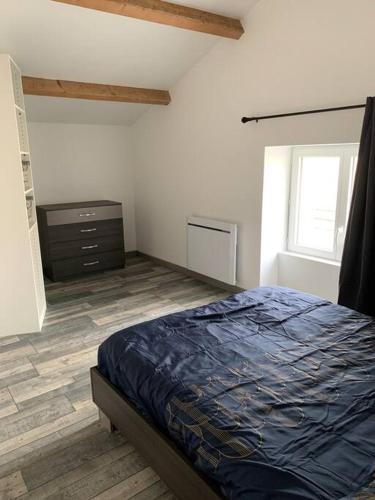 a bedroom with a bed and a dresser and a window at P’tit Gîte du prieuré in Champdolent