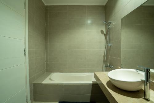 a bathroom with a sink and a bath tub at The Suites near AUC by Elegant Hospitality in Cairo