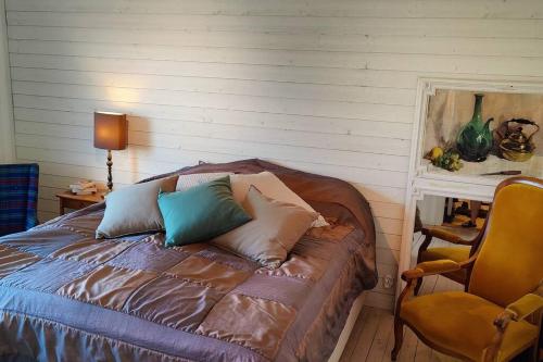 a bedroom with a bed with pillows and a chair at Spacious House near Sea - Delightful shelted garden in Varberg