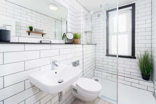 a white bathroom with a sink and a toilet at Ivar's Place in St Ives