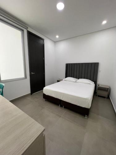 a bedroom with a bed and a large window at Hotel Emerawaa Centro Historico in Ríohacha
