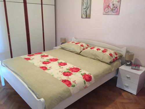 a bedroom with a bed with red flowers on it at Apartment Mila in Split