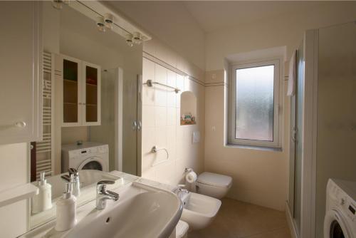 a white bathroom with a sink and a toilet at La Quercia casa vacanza Imperia in Imperia