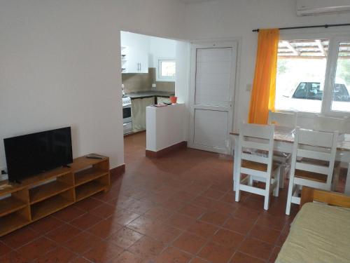 ein Wohnzimmer mit einem TV, einem Tisch und Stühlen in der Unterkunft Coneta, casa de Dios in San Fernando del Valle de Catamarca