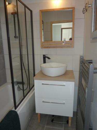 a bathroom with a sink and a mirror and a tub at Houlgate in Houlgate