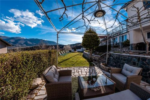 a patio with chairs and a table with a view at Lisets Villa in Gorna Brestnitsa