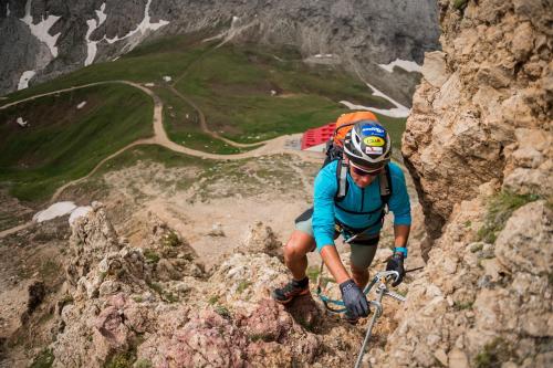 a man is climbing up a rocky mountain at Binterhof in Castelrotto